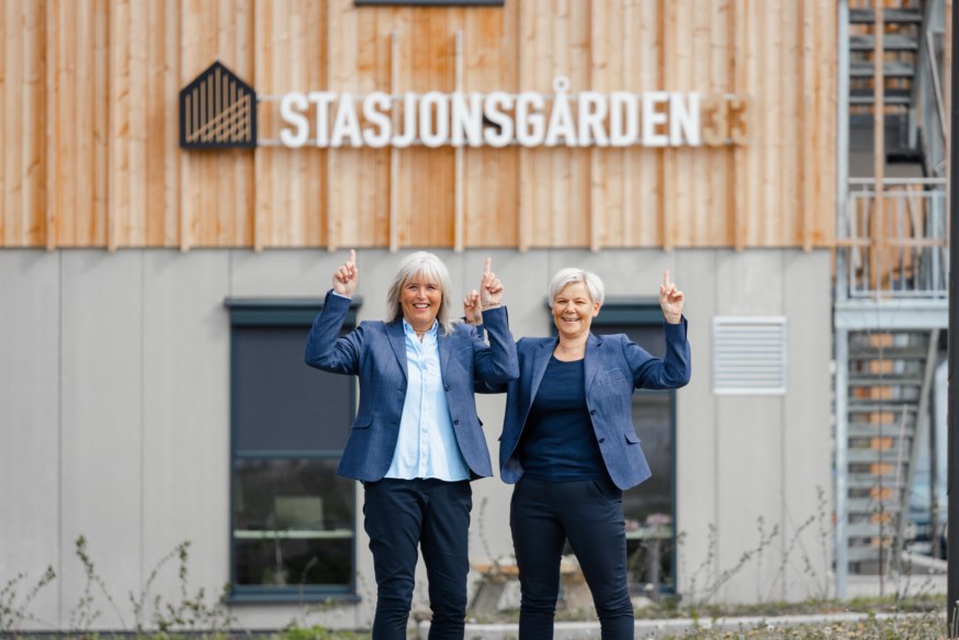 Aud Irene og Annette står utenfor Bø-kontoret og peker opp og smiler