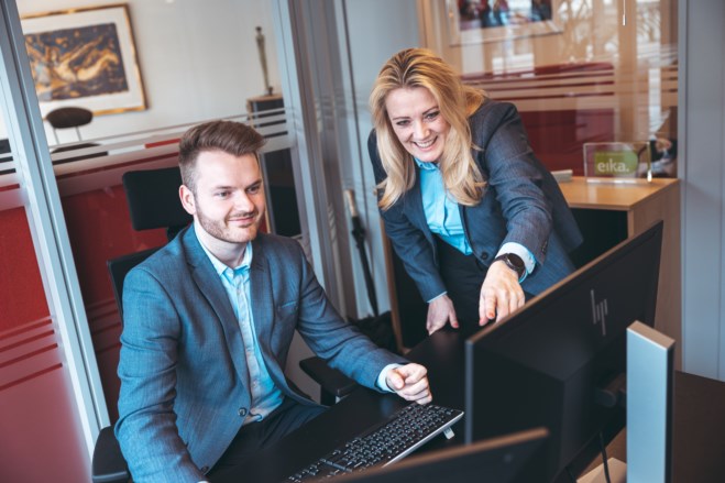 Chris Robin Hakkelberg og Anita Bråthen ser på pc-skjerm og smiler